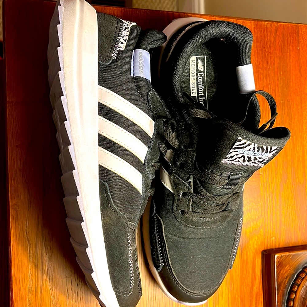 Black adidas with white sole and leopard print accents.